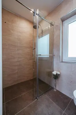 a glass shower in a bathroom with a window at Apartment Oddih with terrace and private SAUNA in Bled