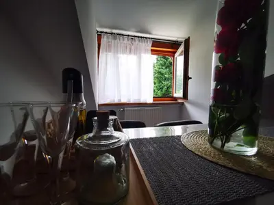 a table with a vase of flowers and a window at Rose 8 Bled in Bled