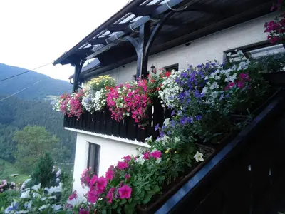 a building with lots of flowers on a balcony at Apartma in sobe Tanja in Podbrdo