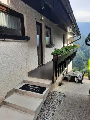 a porch of a house with a sign on it at Apartma in sobe Tanja in Podbrdo