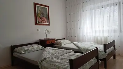 a room with two beds and a window with at Apartma in sobe Tanja in Podbrdo