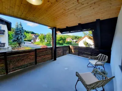 a balcony with two chairs and a wooden ceiling at Rooms Optim in Ptuj