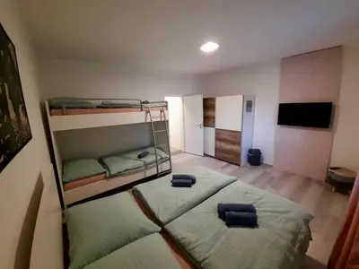 a bedroom with two bunk beds and a flat screen tv at Rooms Optim in Ptuj