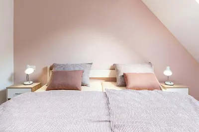 a bedroom with two beds with pillows and two lamps at Apartmaji Rupnik in Bohinjska Bistrica