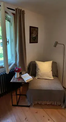 a bed in a room with a table next to a window at Apartma in sobe PR'OBJAN in Bohinj