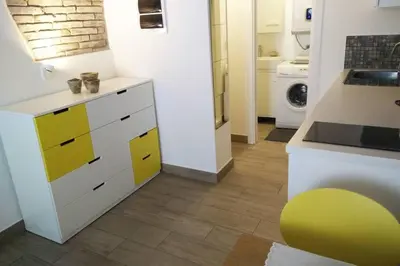a kitchen with yellow and white cabinets in a room at OLD TOWN 14 in Ljubljana