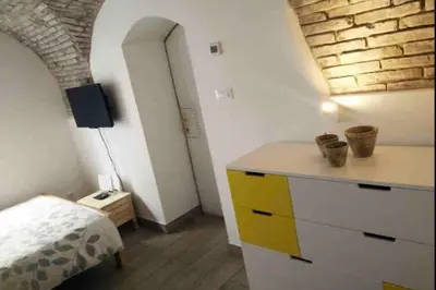 a room with a dresser and a bedroom with a brick wall at OLD TOWN 14 in Ljubljana