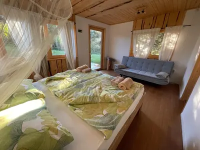 a bedroom with two beds and a blue couch at Boutique Glamping Divja DiVine in Zgornja Korena