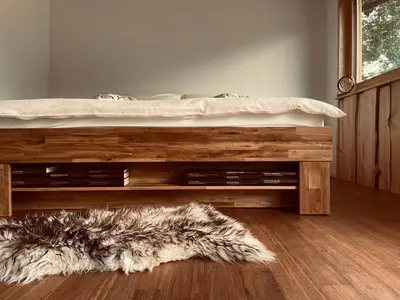 a bedroom with a bed and a rug on the floor at Boutique Glamping Divja DiVine in Zgornja Korena