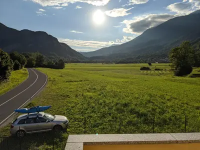 a car with a surfboard on the roof parked on a road at Apartment Nona Polda in Kobarid