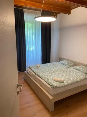 a bedroom with a bed and a large window at Apartment Nona Polda in Kobarid