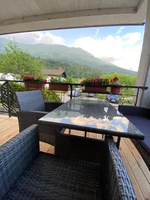 a table on a balcony with a view of mountains at Apartma pri nani in Kobarid
