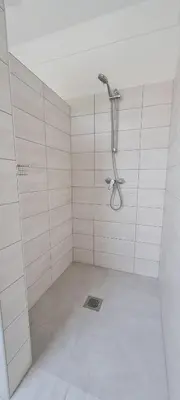 a bathroom with a shower in a white room at Nona BB in Postojna