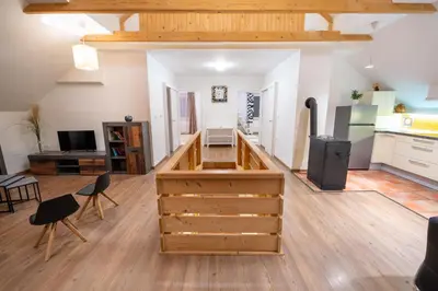 a kitchen with wooden cabinets and a living room at APARTMA VESTER - Large 3-Bedroom Near Bled in Bled