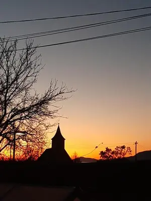 a silhouette of a church with the sunset in the background at APARTMA VESTER - Large 3-Bedroom Near Bled in Bled