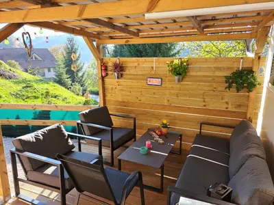 a patio with a couch and tables and chairs at Lexi Zen House in Kamnik