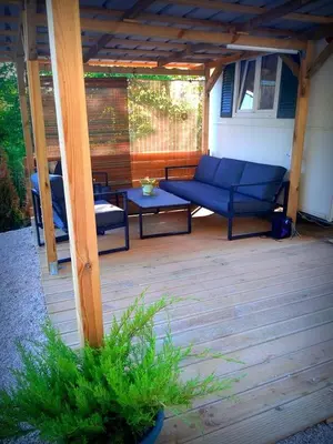 a covered patio with a blue couch and a table at Lexi Zen House in Kamnik