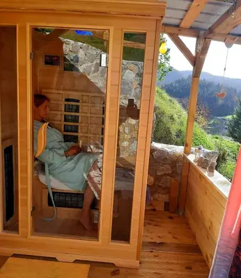 a man sitting in a cage in a wooden house at Lexi Zen House in Kamnik