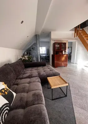 a living room with a large couch and a table at Hiša Srečo in Begunje na Gorenjskem