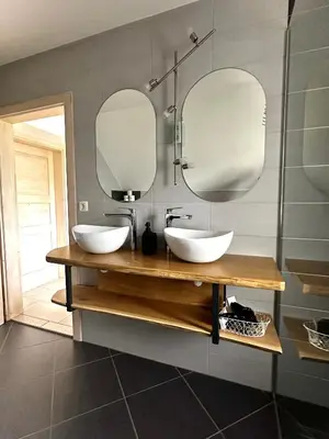 a bathroom with two sinks and two mirrors at Hiša Srečo in Begunje na Gorenjskem