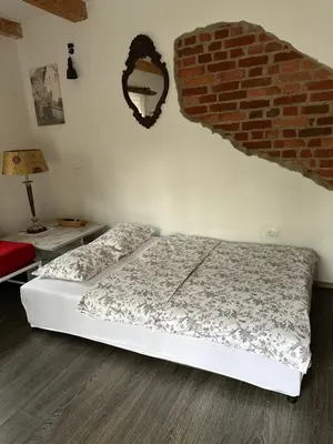 a bedroom with a bed and a brick wall at Hiša Srečo in Begunje na Gorenjskem