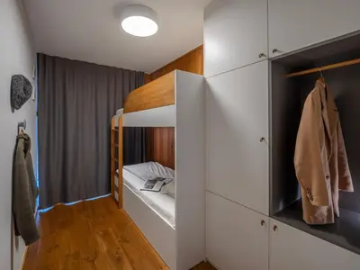 a small bedroom with white cabinets and a bunk bed at SKI Gothia in Kranjska Gora