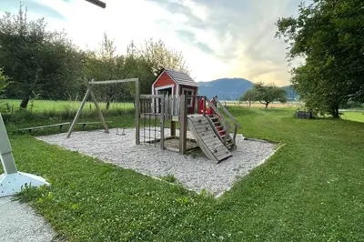 a playground with a slide in the grass at Grandma's House in Radlje ob Dravi
