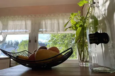 a bowl of fruit on a table next to a vase at Grandma's House in Radlje ob Dravi