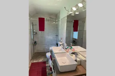 a bathroom with a white sink and a shower at Grandma's House in Radlje ob Dravi