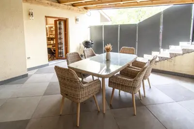 a dining room with a glass table and wicker chairs at Apartment THE VIEW HerMes arT in Sežana