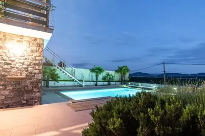 a swimming pool in front of a building at Apartment THE VIEW HerMes arT in Sežana