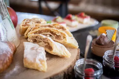 a wooden cutting board with pastries on a table at House Troha - Rooms & Apartments in Bled