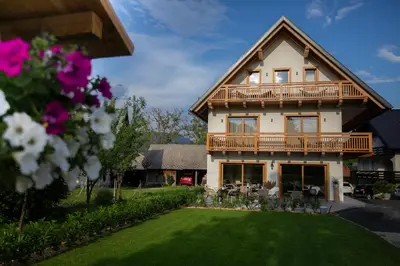 a large house with a balcony and a lawn at House Troha - Rooms & Apartments in Bled