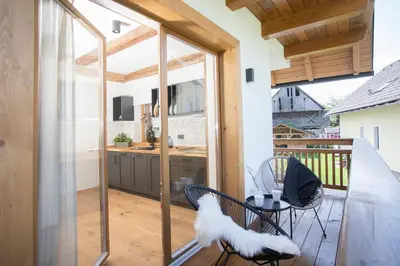 a kitchen with glass doors and a table and chairs at House Troha - Rooms & Apartments in Bled