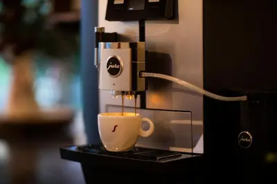 a coffee maker is making a cup of coffee at House Troha - Rooms & Apartments in Bled