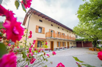 an exterior view of a house with pink flowers at Apartma Korada in Deskle