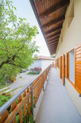 a balcony of a building with wooden railing and trees at Apartma Korada in Deskle