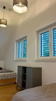 a bedroom with a bed and two windows at The Valley Queens in Bovec