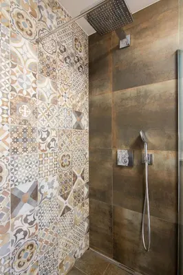 a bathroom with a shower with a tile wall at The Valley Queens in Bovec
