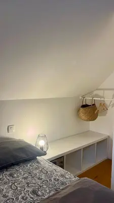 a bedroom with a bed and a white wall at The Valley Queens in Bovec