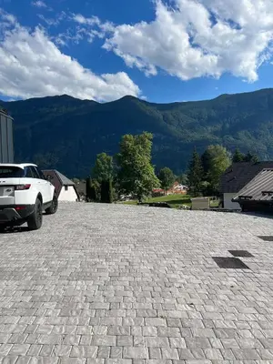 a car parked in a parking lot with mountains in the background at The Valley Queens in Bovec