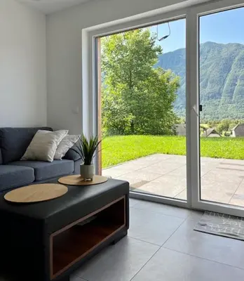 a living room with a couch and a large sliding glass door at The Valley Queens in Bovec