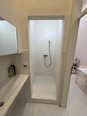 a white shower with a hose in a bathroom at INDUSTRIAL STUDIO 2 in Ljubljana