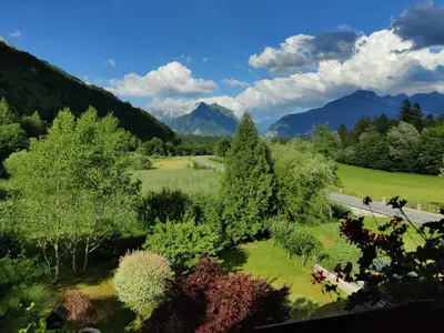 a road in a field with trees and mountains at Apartma Dobra misel in Bovec