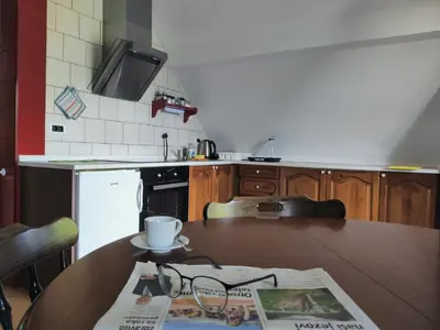 a kitchen with a table with a newspaper on it at Apartma Dobra misel in Bovec
