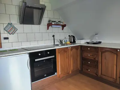 a kitchen with wooden cabinets and a black oven at Apartma Dobra misel in Bovec