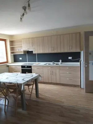 a kitchen with wooden cabinets and a table in it at Apartmaji Maki in Bled