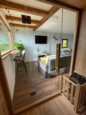 a living room with a couch and a glass wall at Lunela estate with sauna in Cerklje na Gorenjskem