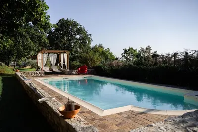 a swimming pool in a yard with a brick wall at 9b-The Tiny House in Sežana