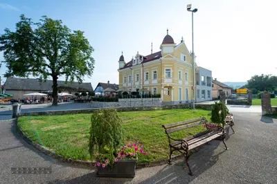 a bench in front of a large yellow building at Dvorec Gregorčič in Smarjeske Toplice